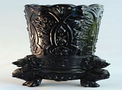 Black glass vase with three lion feet, also seen in a waxy white colour